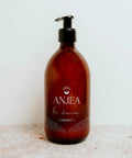 Liniment La douceur Anjea en flacon de 500 ml, liquide apaisant pour le change, bouteille transparente avec étiquette colorée.