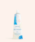 Crème Douce Minois Paris hydratante pour visage et corps, texture douce et onctueuse, flacon blanc avec capuchon.