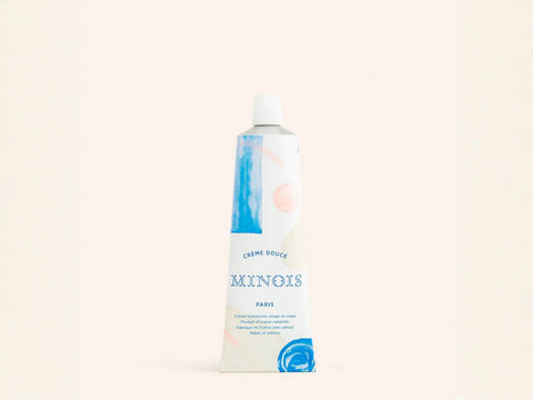 Crème Douce Minois Paris hydratante pour visage et corps, texture douce et onctueuse, flacon blanc avec capuchon.