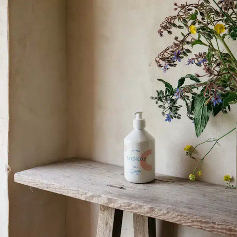 Lait pour le corps Minois Paris, hydratation douce pour visage et corps, texture onctueuse, appliqué sur peau de bébé.