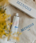 Soin démêlant Minois Paris pour démêlage et hydratation, flacon blanc avec pompe, adapté aux cheveux.