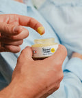 Baume visage bébé bio Pototam pour peau sèche et sensible, texture douce et hydratante, appliqué sur le visage et le corps.